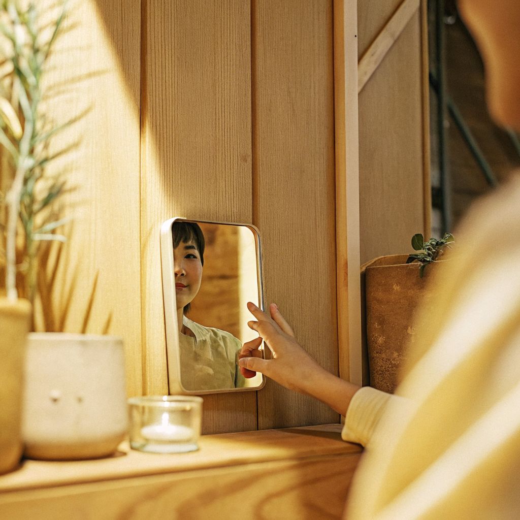 person noticing themselves in a mirror and smiling
