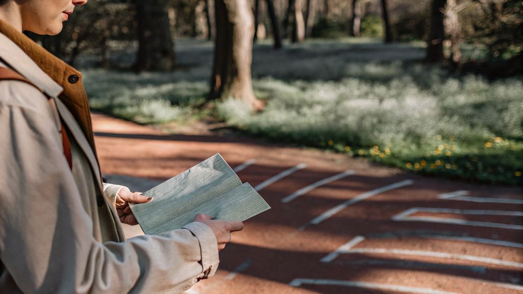Awareness and change moment: person holding a folded map at a crossroads