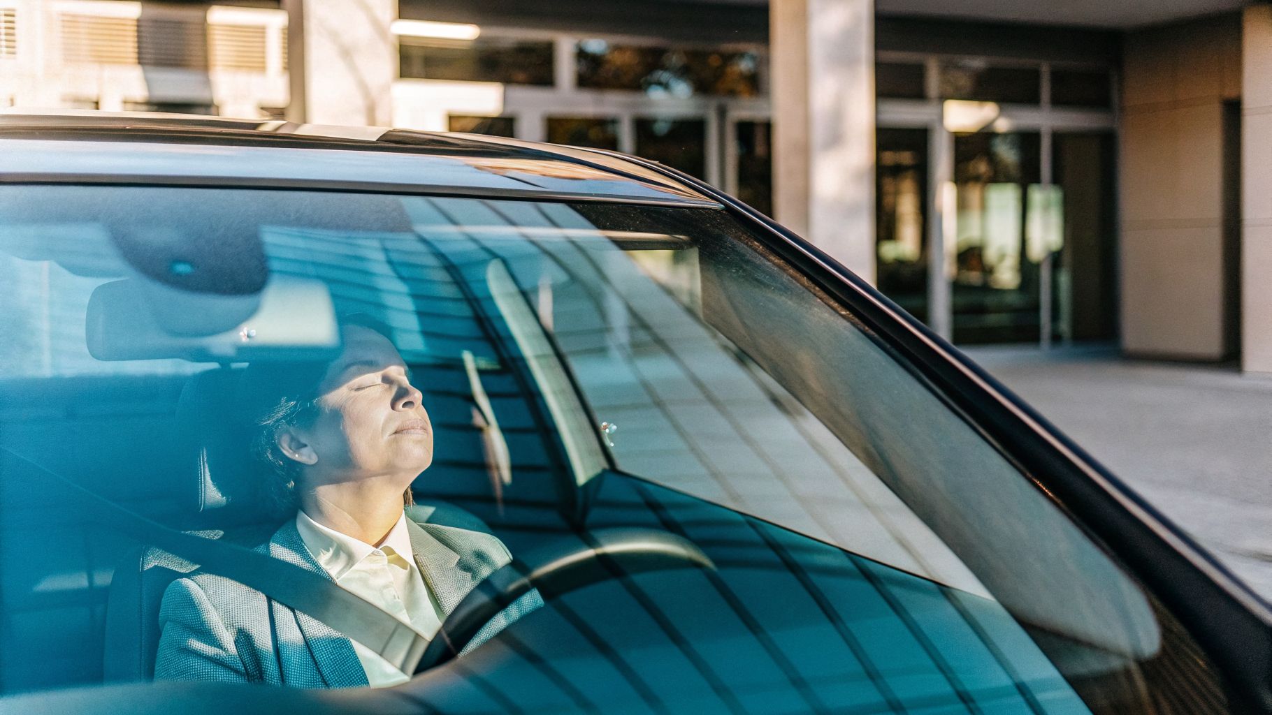 Person in car outside an office feeling dread—burnout identity patterns at work