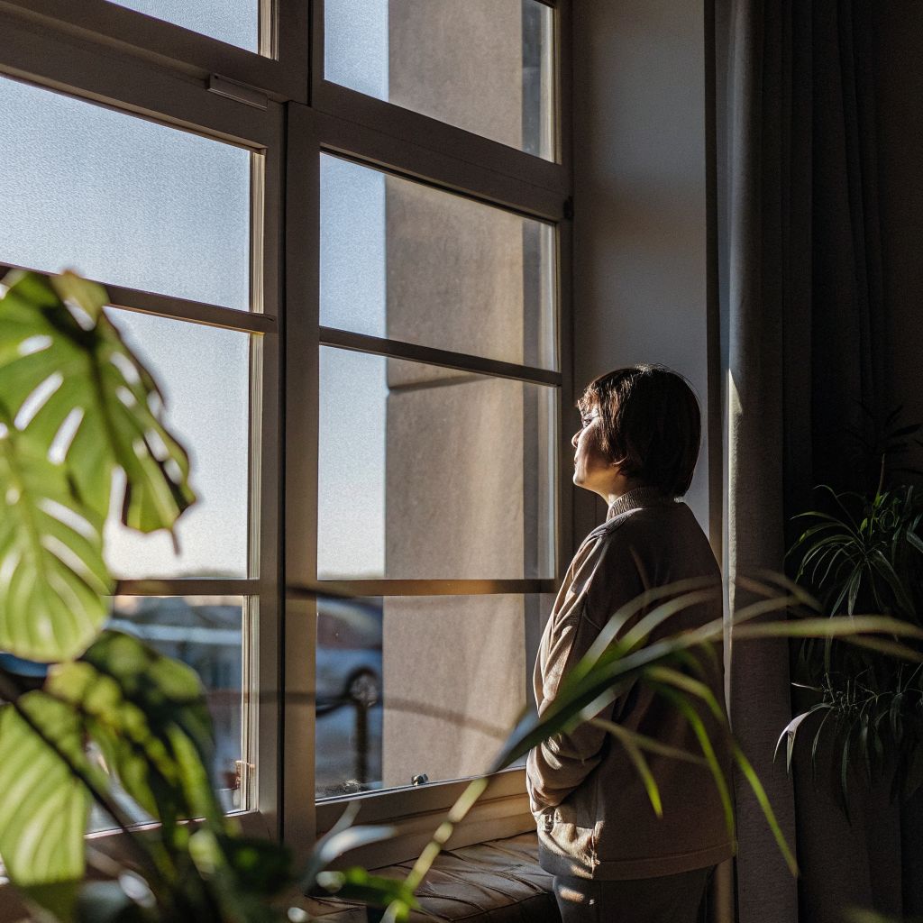 A small pause creates the space between stimulus and response as a person looks out a city window