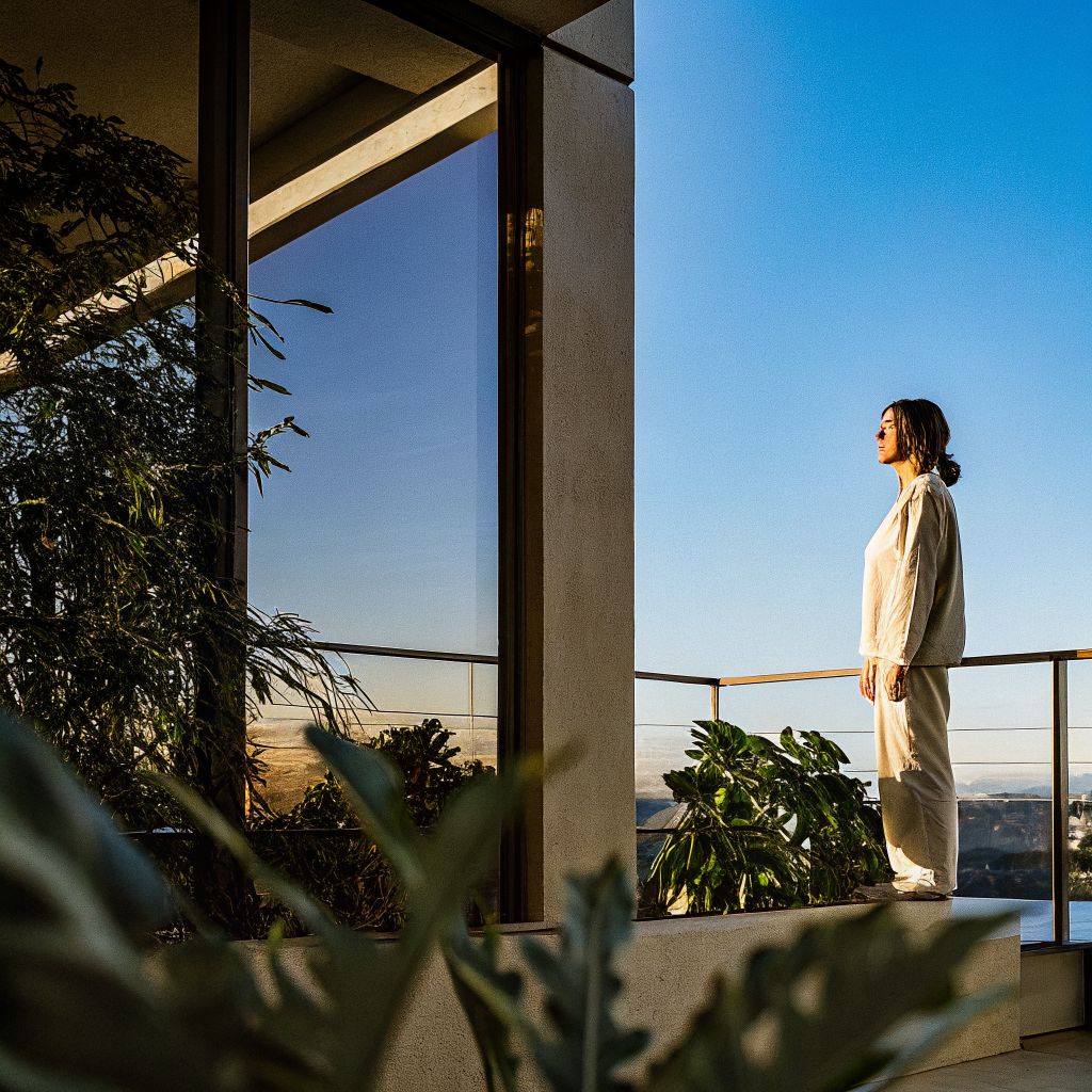 Person pausing at sunrise, illustrating the space between stimulus and response