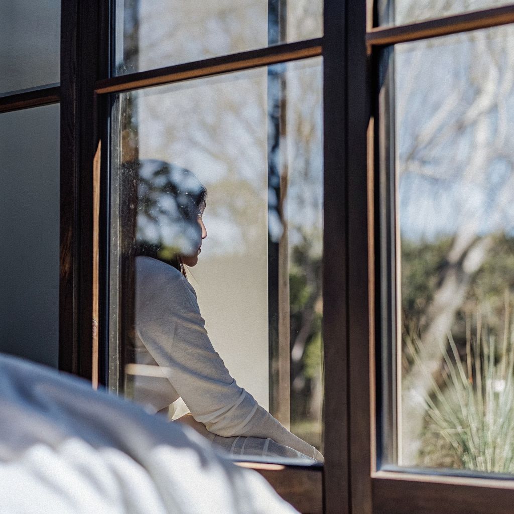 Inner world outer world: person looking out a window with a faint inner landscape overlay