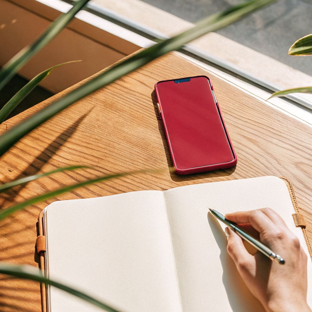 leader reflecting with a notebook, phone face down