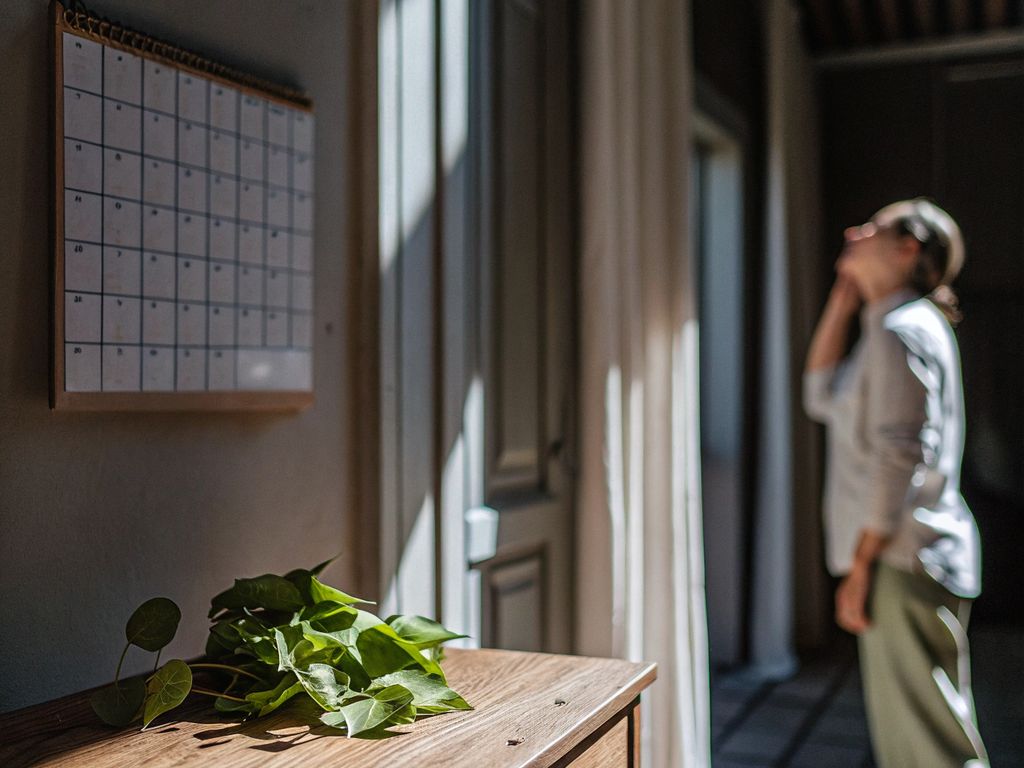 person gazing at a blurred calendar, pondering change