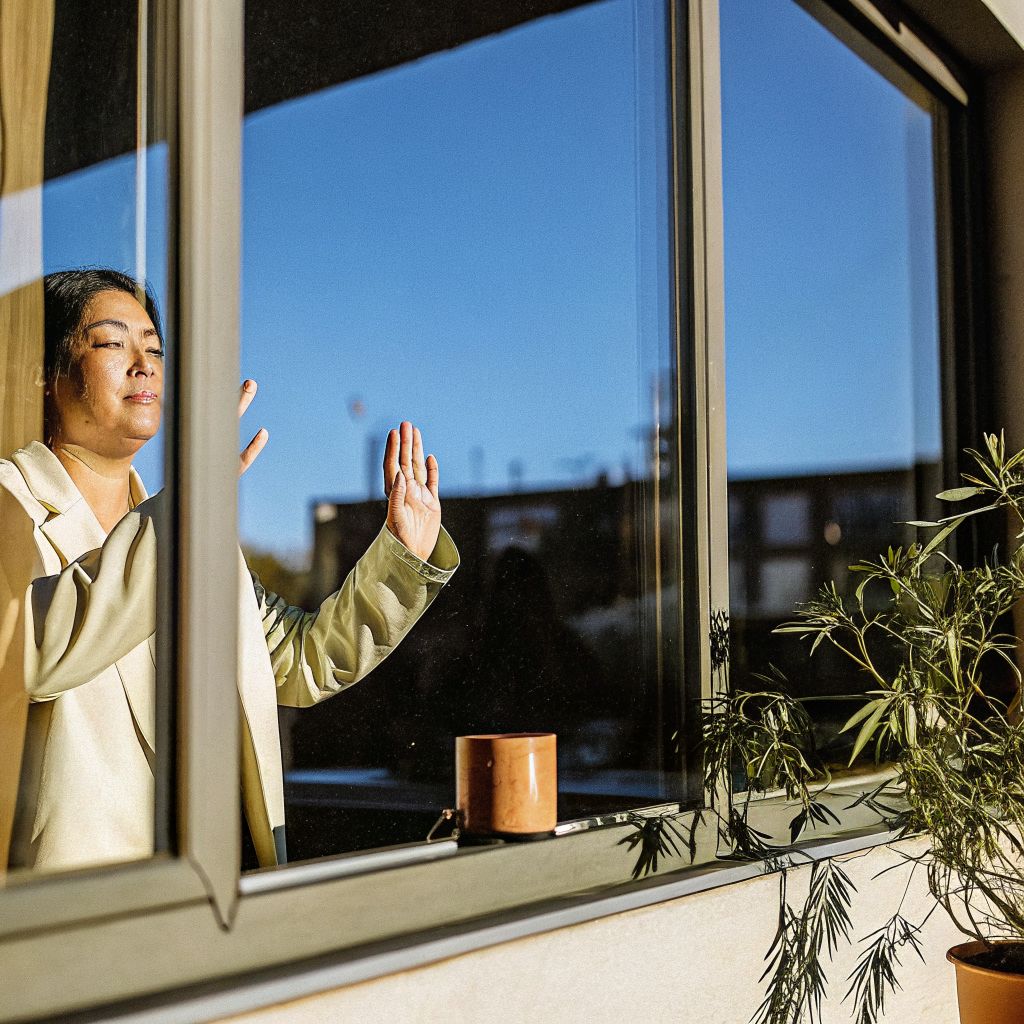 person pausing by a window between meetings