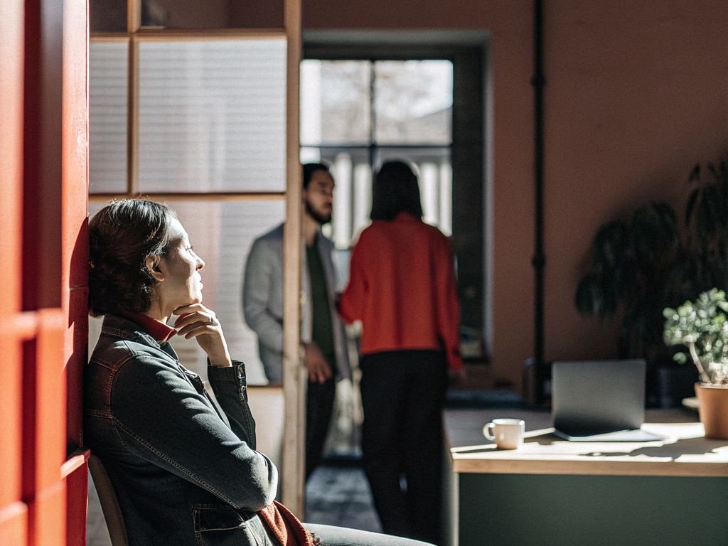 person looking thoughtful in a busy office