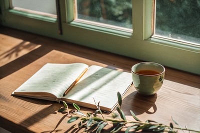 journal by a window with tea and morning light