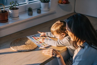 Parent and child using a feelings chart at the kitchen table