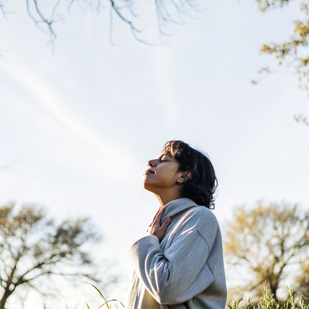 Person pausing mid-walk with hand on chest, noticing inner alignment signals