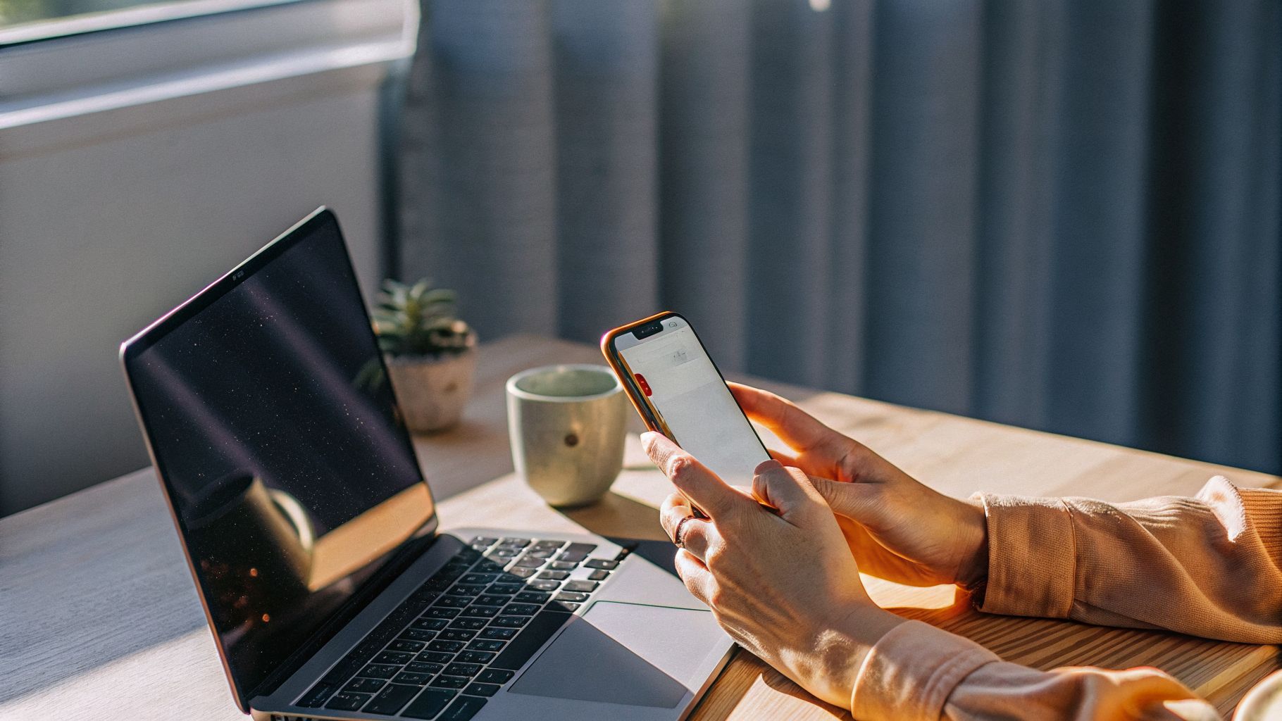 Art of life moment: person at a desk noticing a phone notification while writing an email