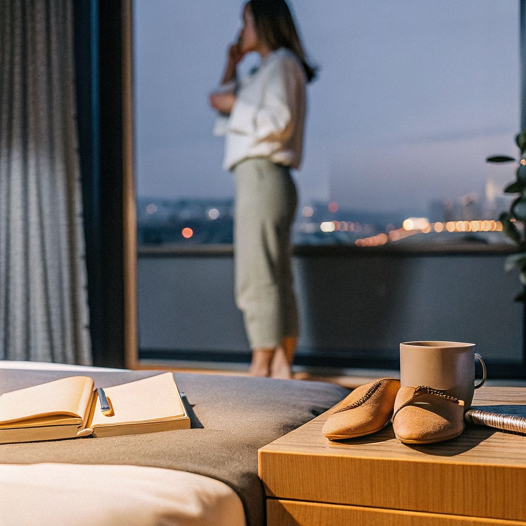 Businesswoman in a hotel room at night, reflecting on living in alignment
