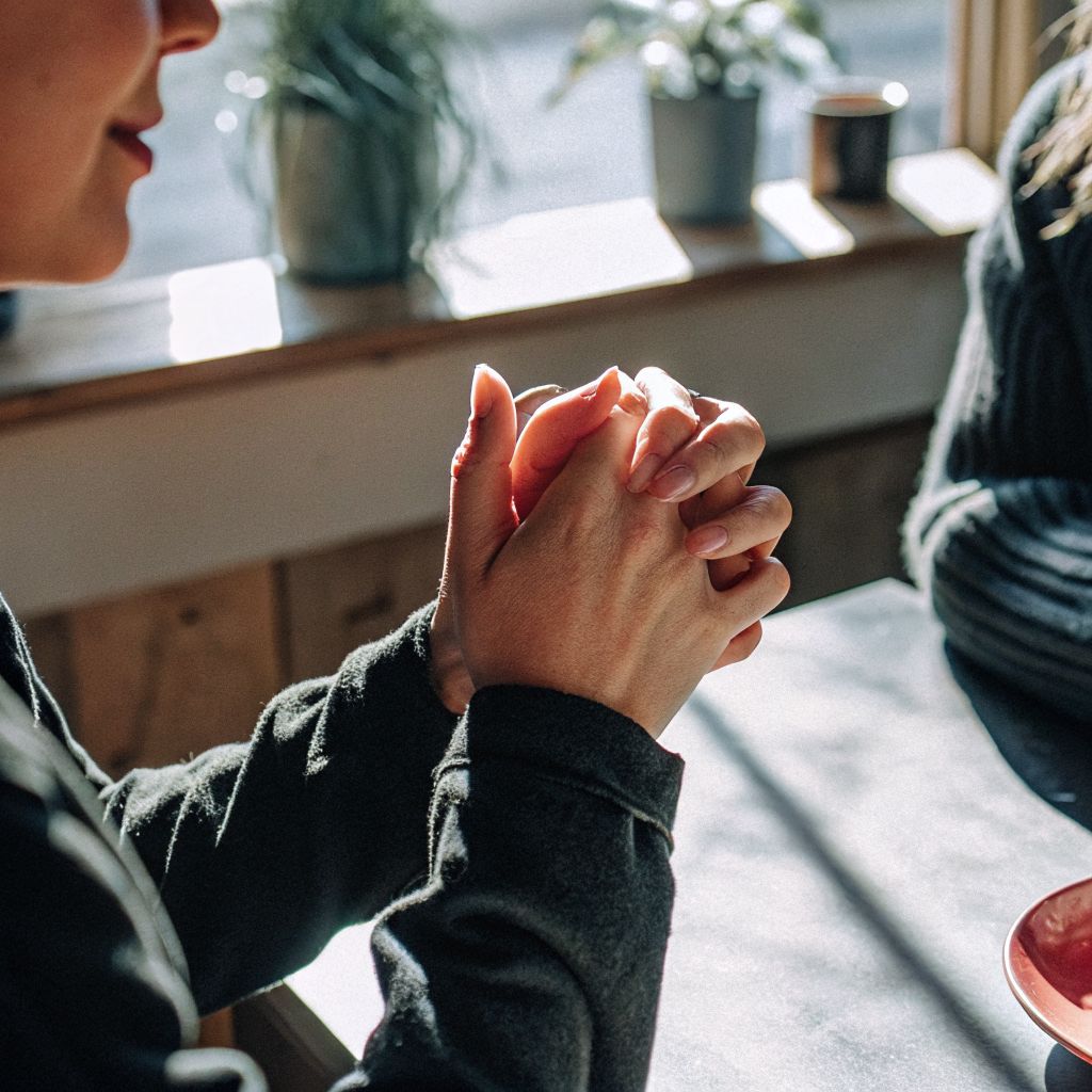 Person pausing mid-conversation, breathing to find the space between stimulus and response