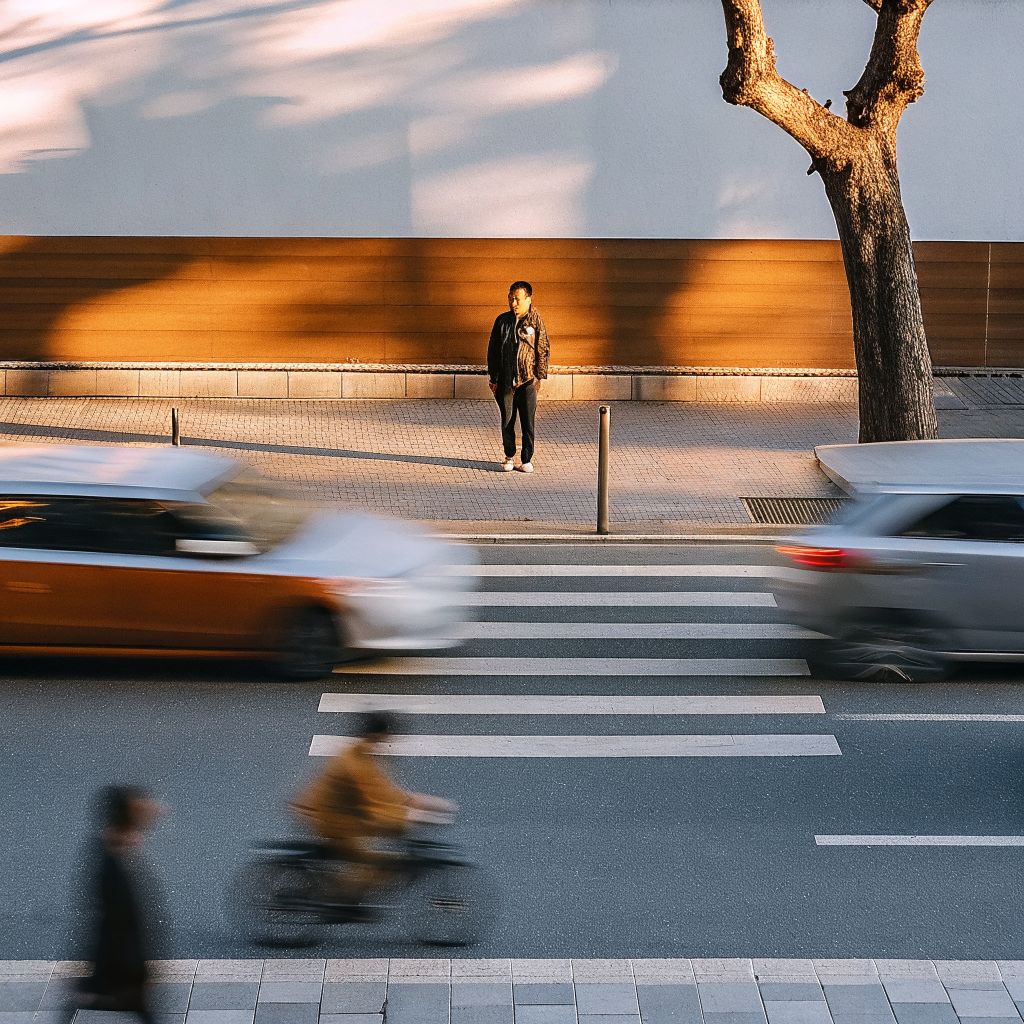 person standing still while a busy city moves around them