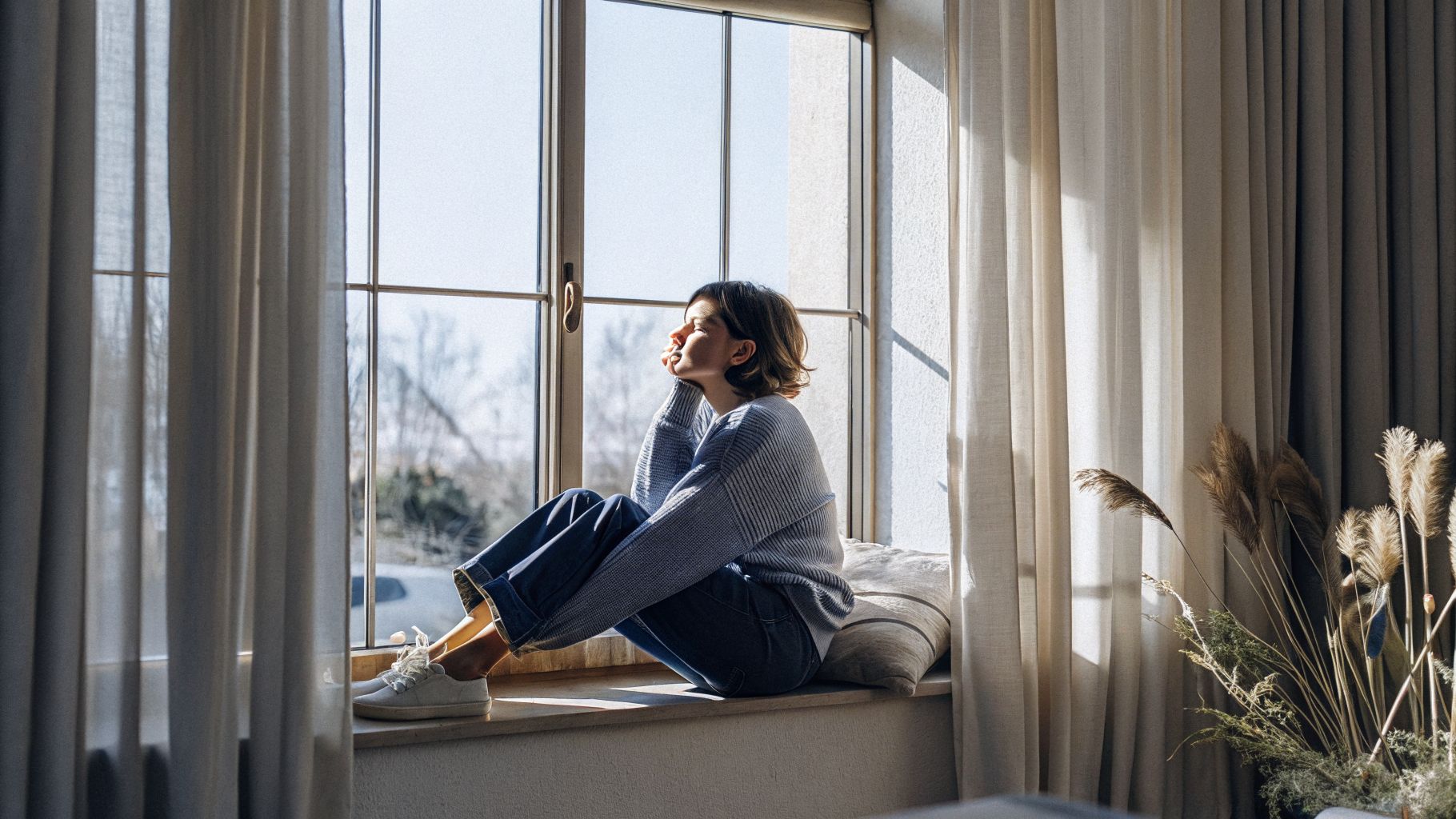 Internal conditioning reflected in a person looking out a window in a thoughtful mood