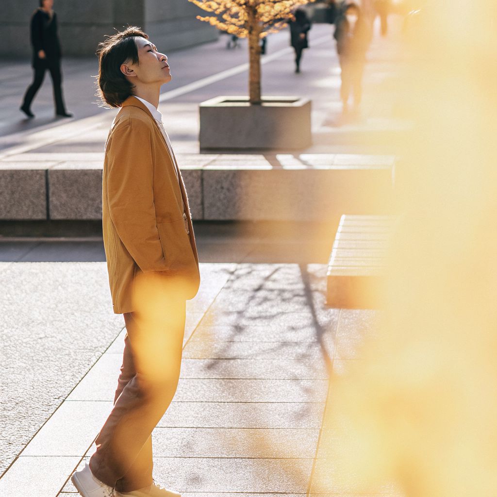 Space between stimulus and response—person pausing on a city street with a calm breath