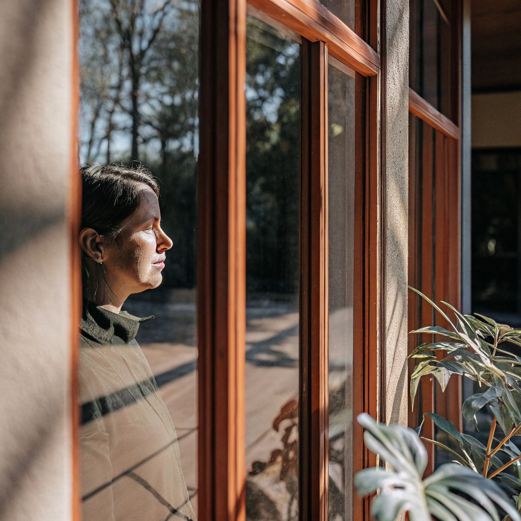 Person looking through a reflective window showing how the inner world creates outer world perception