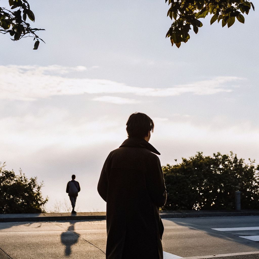 A person pausing at a crossroads in a city street