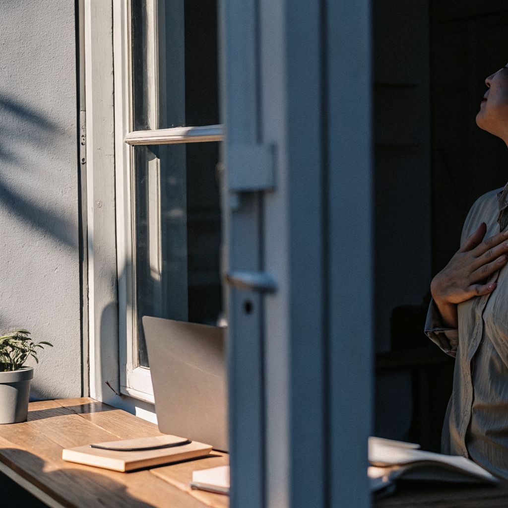 Inner world outer world moment: person pausing at a doorway, noticing their breath