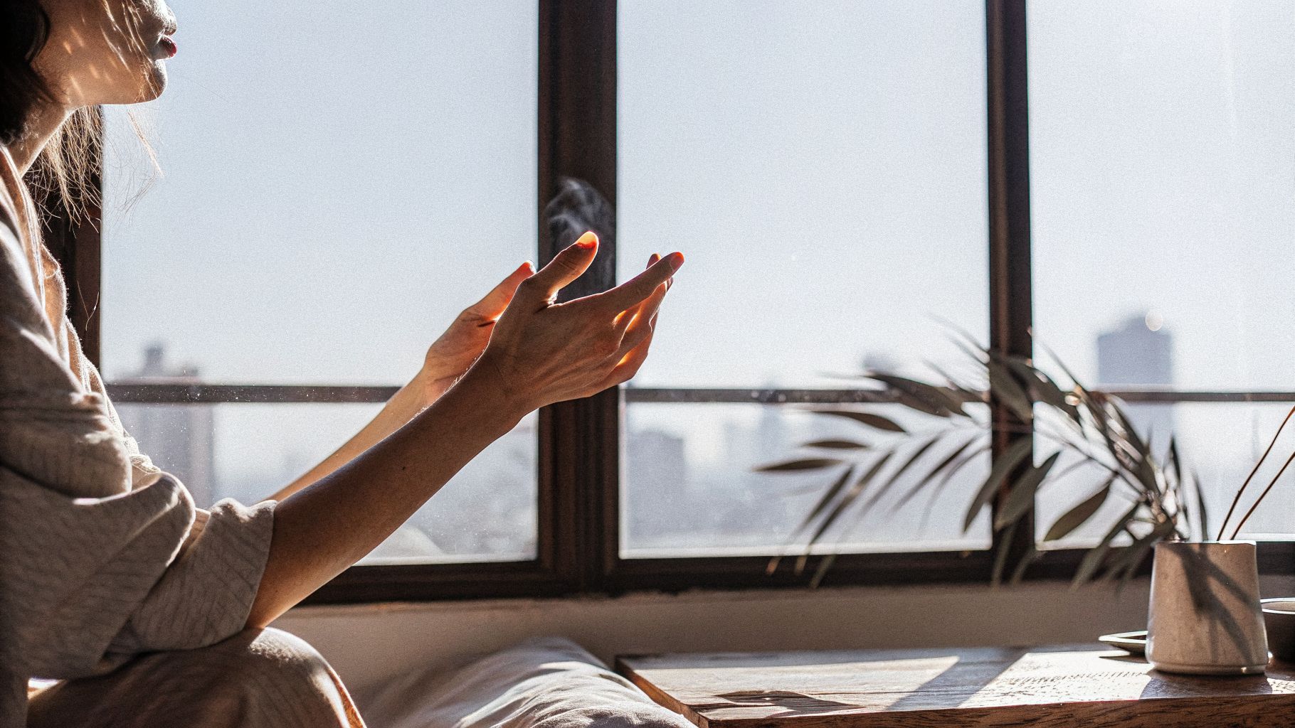 Awareness and change: a person pausing by a window in morning city light