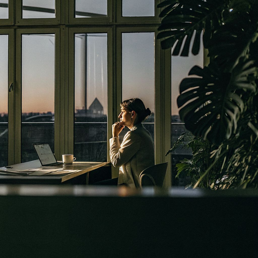 Leader alone in an office at dusk, reflecting on conscious leadership and emotional load